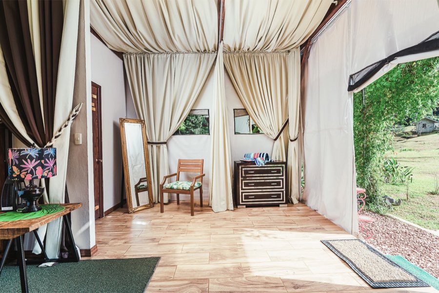 Listing photo of the tent cabin entryway with curtains, a floor mirror, and a dresser
