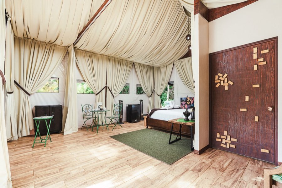 Listing photo of the bedroom with a canopy bed and a carved wood door