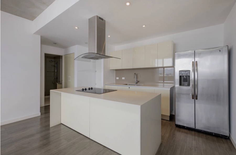 Listing photo of the kitchen and open living area beyond