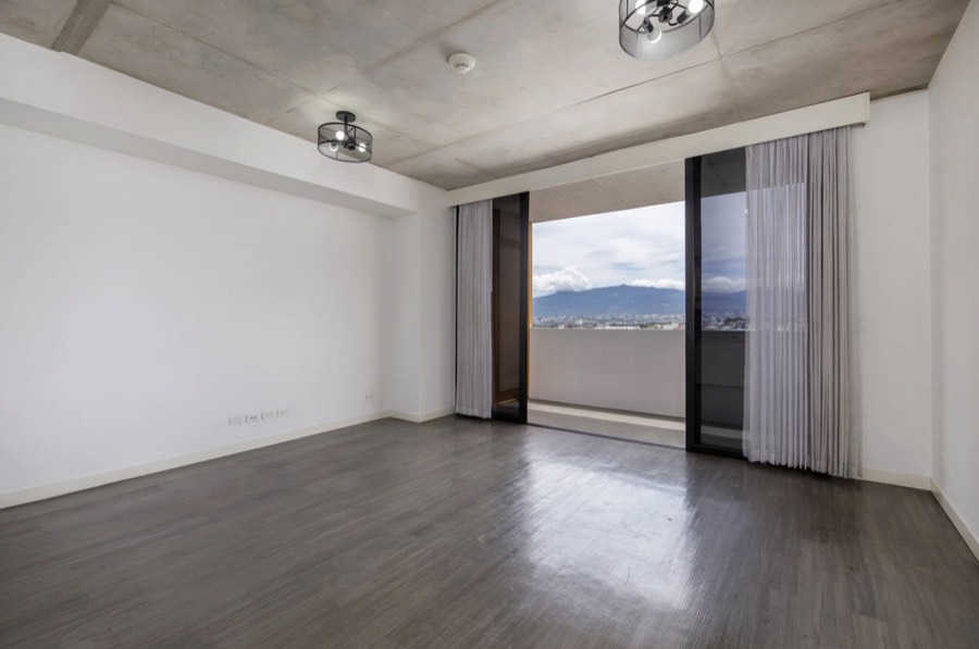 Listing photo of an empty room with a balcony and mountain view